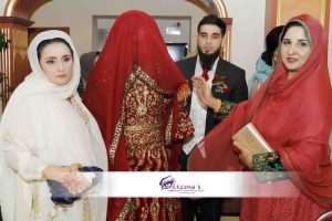 A muslim bride with head covering being escorted by family on Rukhsati